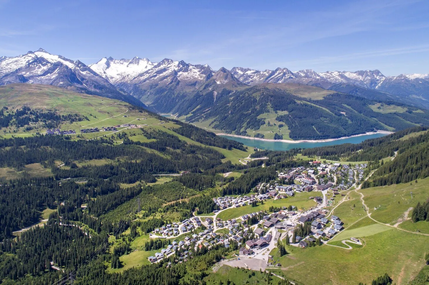 Luftaufnahme von Königsleiten im Sommer mit Bergpanorama und Stausee